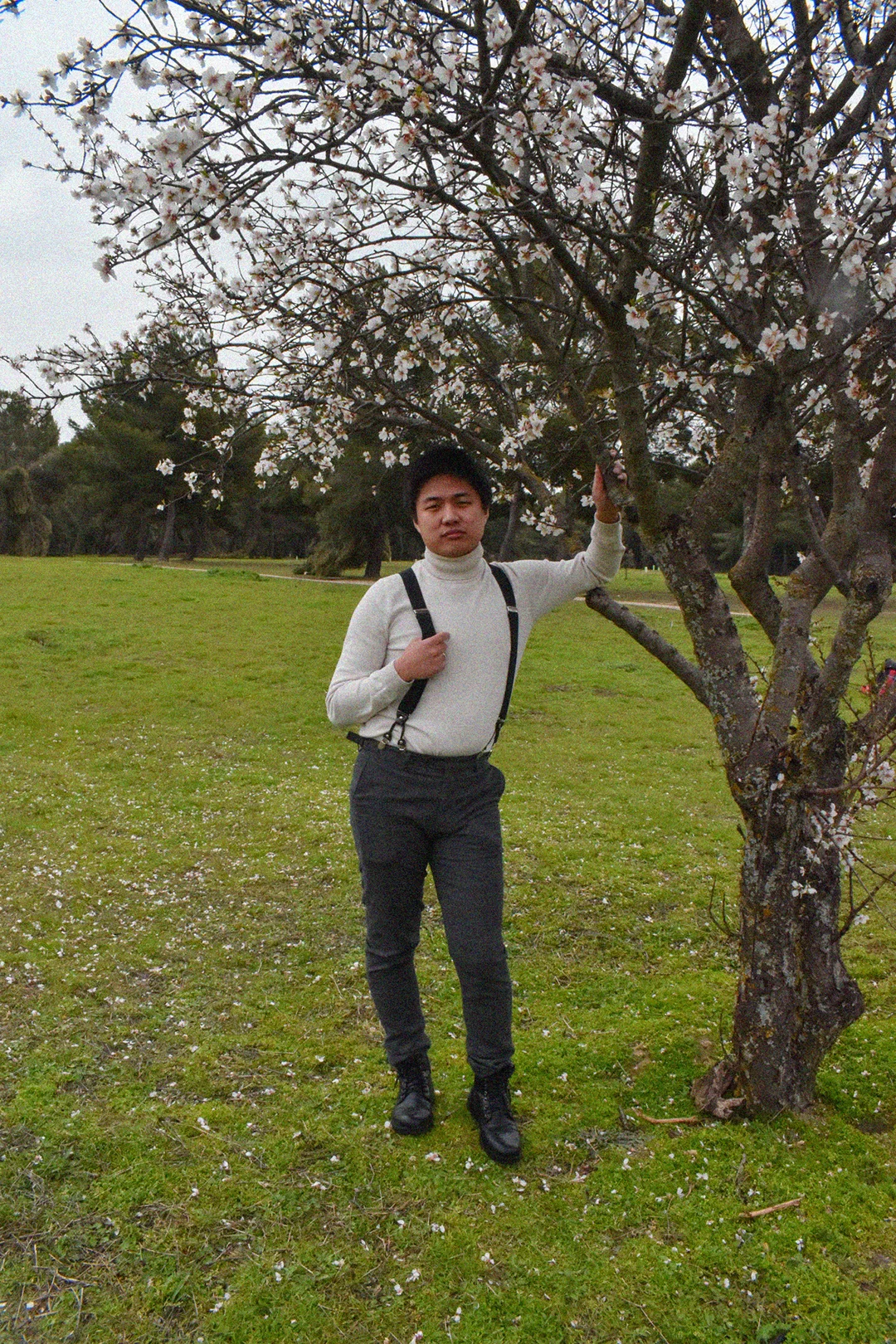 un hombre apoyado en un árbol de cerezo